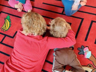 Barn og voksen leger på gulvet